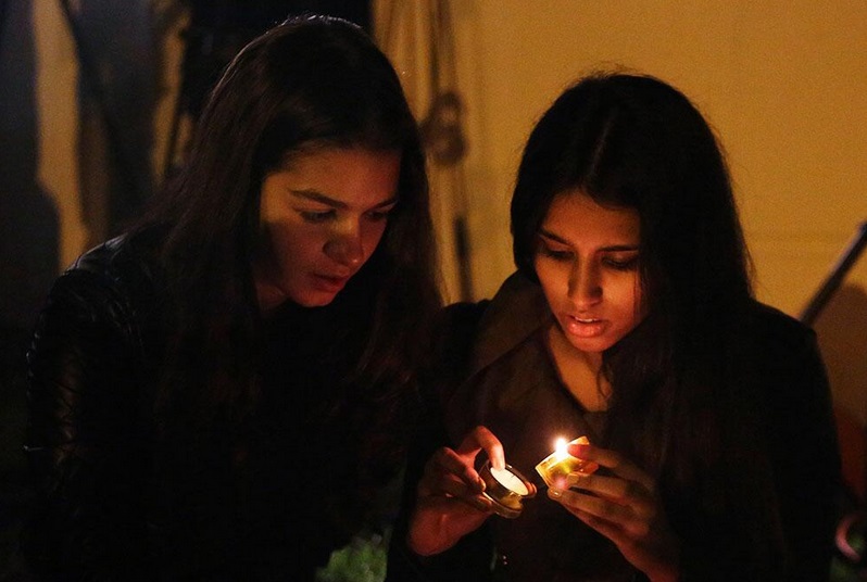 mujeres encendiendo velas rezos