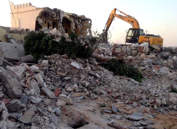 Libyan Islamist hardliners use a bulldozer to raze the mausoleum of Al-Shaab Al-Dahman near the centre of Tripoli on August 25, 2012. Islamist hardliners bulldozed part of the revered mausoleum in Tripoli in the second such attack in Libya in two days, an AFP correspondent reported. AFP PHOTO/MAHMUD TURKIA        (Photo credit should read MAHMUD TURKIA/AFP/GettyImages)